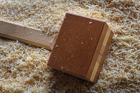 A handmade woodworking mallet laying on top of some wood shavings.の写真素材