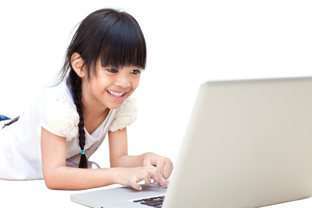Happy and smiling little girl with laptop isolated on whiteの写真素材
