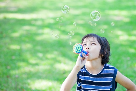Little boy blowing soap bubblesの写真素材