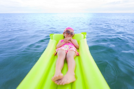 Portrait little girl with air mattress on the seaの写真素材