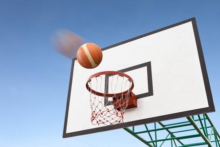Motion basketball in air over hoopの写真素材