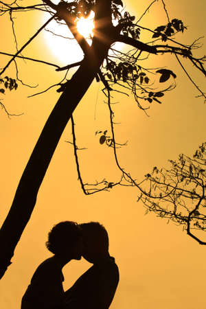 Silhouette a young couple embracingの写真素材