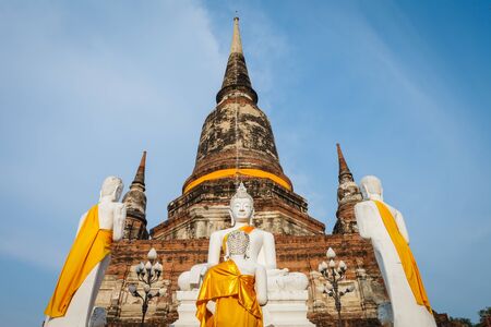 White buddha statue in front of ancient pagoda in Ayuthaya, Thailandの写真素材