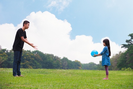 Brother and sister playing ball in parkの写真素材