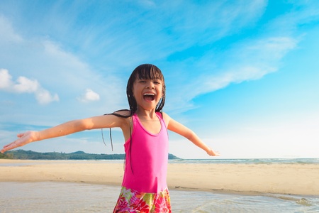 Happy smiling little girl on beachの写真素材