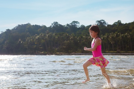 Little girl running beach , Splashing water in seaの写真素材