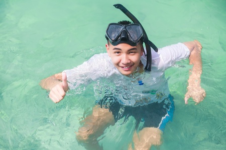 Asian teenager boy diving in seaの写真素材