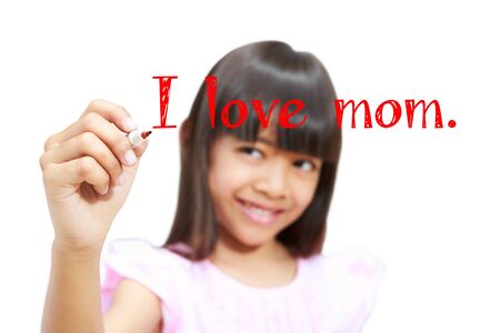 Closeup asian little girl writing I love mom on screen, Isolated on whiteの写真素材