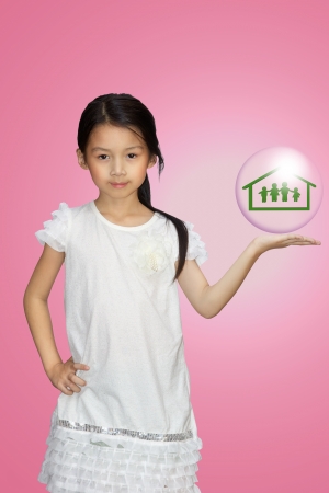 Smiling little girl showing on family symbol over simply backgroundの写真素材
