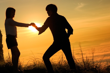 Loving adult couple together outdoor in mountains over scenic sunset sky background の写真素材