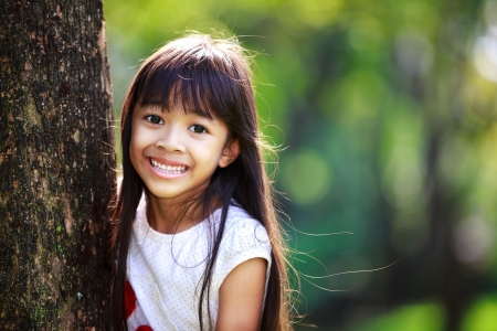 Cute little girl smiling in a park close upの写真素材