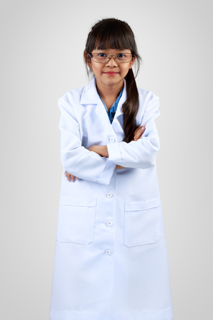 Cute little asian girl dressed like a doctor, Isoated on grey backgroundの写真素材