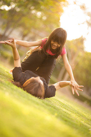 Little girl playing with her mother at outdoorの写真素材