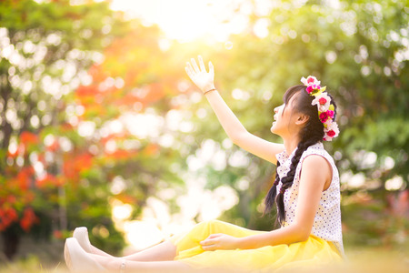 Teenage asian girl sitting on floor in a parkの写真素材