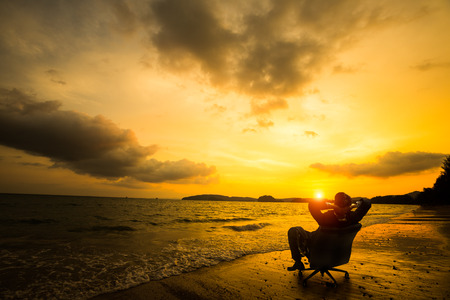 Relaxing businessman sitting on beach, Success in business conceptの写真素材