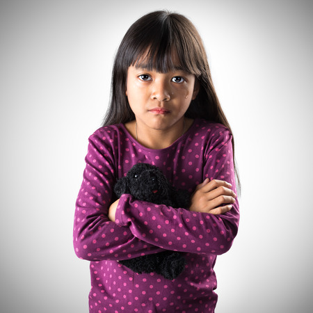 Little asian girl crying with tears rolling down her cheeks, Isolated on grey backgroundの写真素材