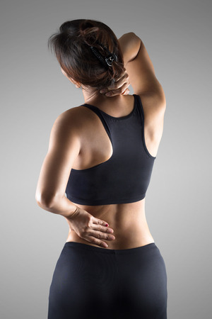 Female with pain back pain and neck pain, Isolated over grey backgroundの写真素材