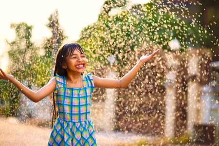 Happy little asian girl in the summer rainの写真素材