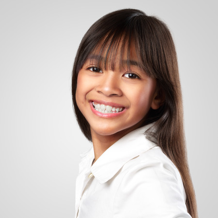 Closeup happy little asian girl Isolated on grey backgroundの写真素材