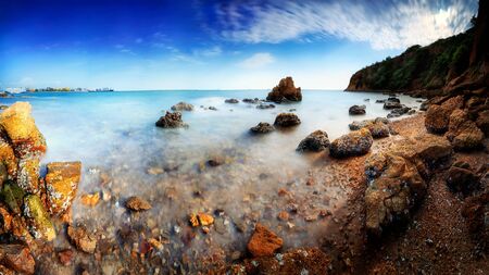 Panorama of long exposure of a rocky beach