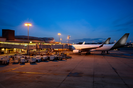 Airplane near the terminal in an airport at the dusk, Changi international airportのeditorial素材
