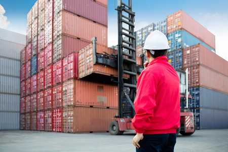 Foreman control loading Containers box from Cargo freight ship