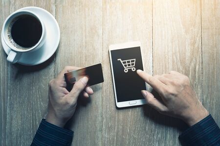 Person hands with credit card and mobile phone at desk, Online shopping conceptの写真素材