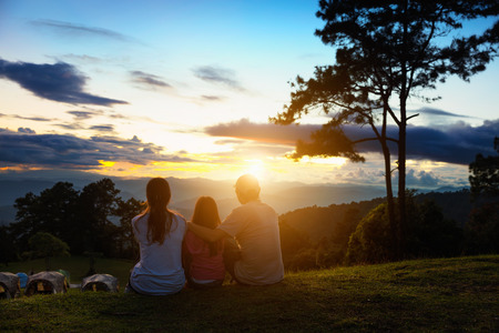 Asian family seat on the top of mountain and look at sunset, Family travel conceptの写真素材