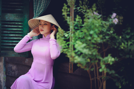 Beautiful vietnamese woman in Ao Dai traditional dress of Vietnam, Ho Chi Minh city Vietnamの写真素材
