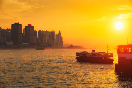 Star ferry passenger boats at sunset in victoria harbour, Hong kongの写真素材