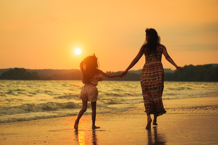 Mother and daughter walking on the beach with sunset, Krabi Thailandの写真素材