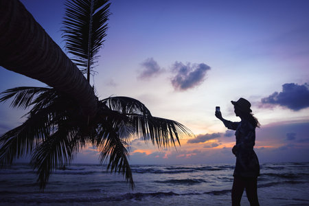 Silhouette woman selfie at beach against sky during sunset, Koh Kut Thailandの写真素材