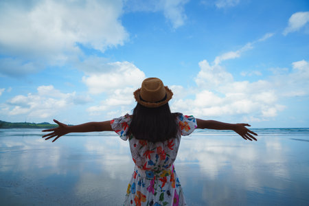 Teenage female traveler standing at the coast looking at view at dawn, Ko Kut Thailandの写真素材