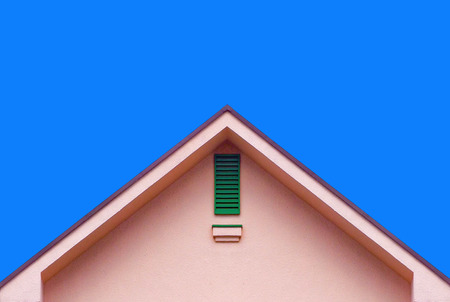Pink house wall gable roof and blue skyの写真素材