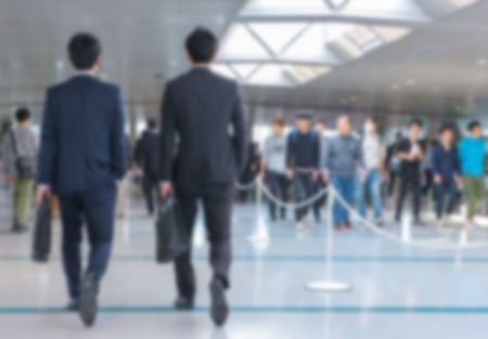 blurred back of business men walking at career job fair.の写真素材