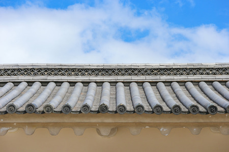 old japanese roof with blue sky and clouds as background.
