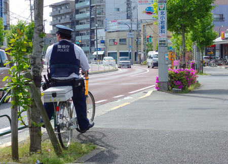 2017 April 05. TOKYO JAPAN. A policeman on bicycle looking for the safty of population in EDOKAWA city.のeditorial素材