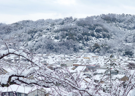 snow covered on japanese town and forest mountain on winter season.の写真素材
