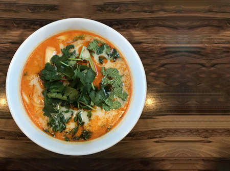 ShangHai hot sauce noodles in red soup bowl on wood table background.