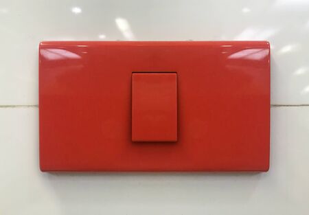 Red switch to turn on the light on wall background.