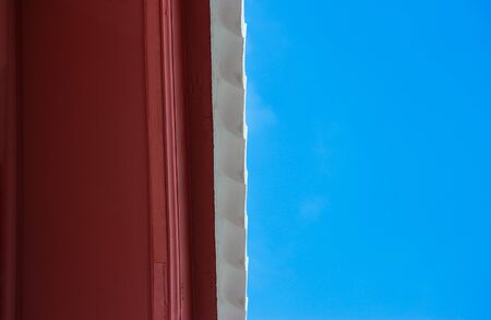 Bottom view of oriental style roof with blue sky background.