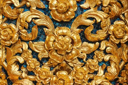 Thai traditional golden peonies flower or kanok pattern design texture wall for temple.の写真素材