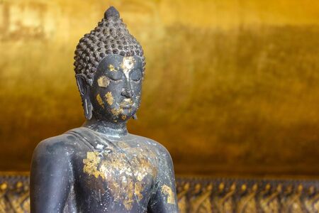 an ancient Black sitting Buddha statue in Wat Pho church.の写真素材