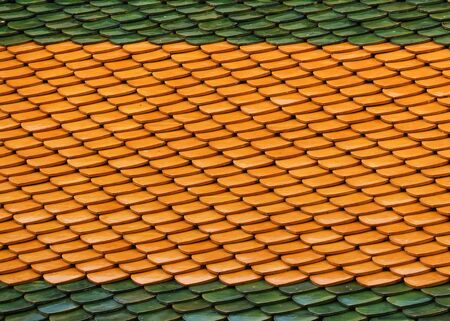 Thai green red and orange color ancient temple roof wall background.