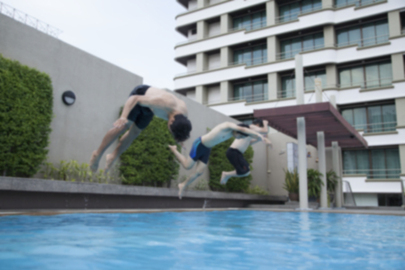 Blur image of three men jump on swimming poolの写真素材