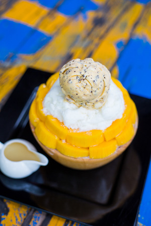 Bingsu mango served with sweetened condensed milk on tableの写真素材