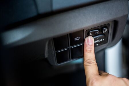 Hand pressing Close up Power window control button on car.の写真素材
