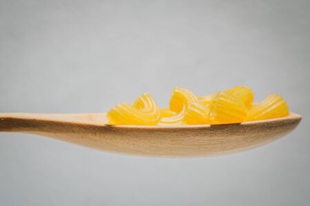 Pasta  in wooden spoons over white background.の写真素材