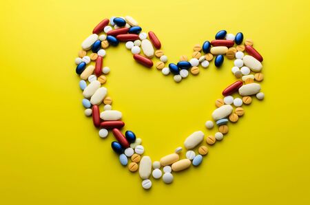 Colorful pills and tablets in shape of heart