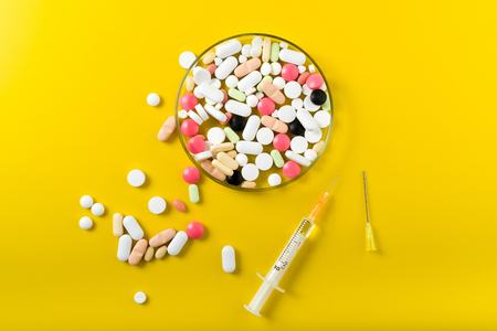 syringe and colorful pill and capsules on background, top viewの写真素材